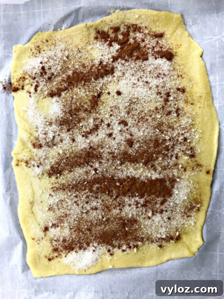 keto fathead cinnamon rolls on a white plate dough with cinnamon and sugar