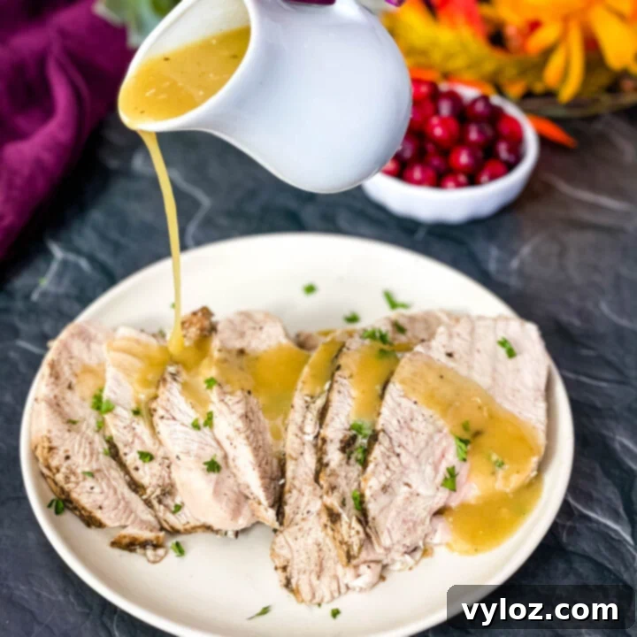 Instant Pot Tender Turkey Breast 9 Cooked turkey breasts with gravy on a white serving plate, with fall decor in the background.