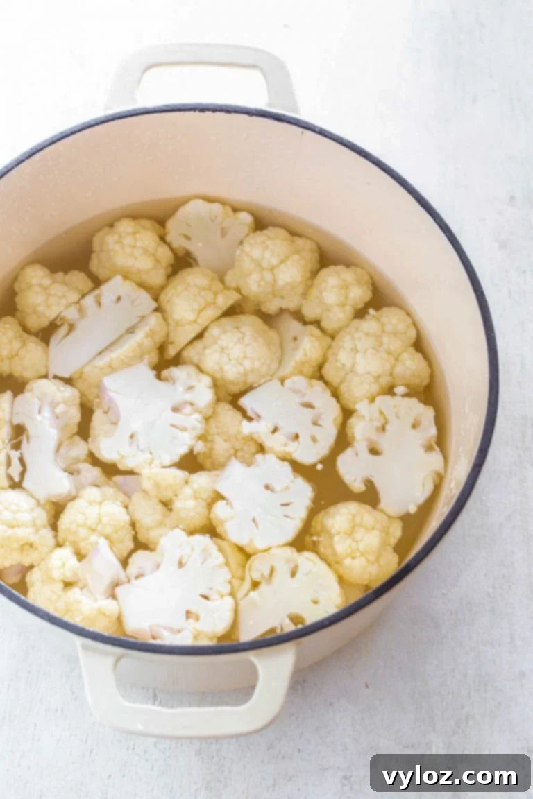 Steamed cauliflower florets in a bowl, ready for mashing
