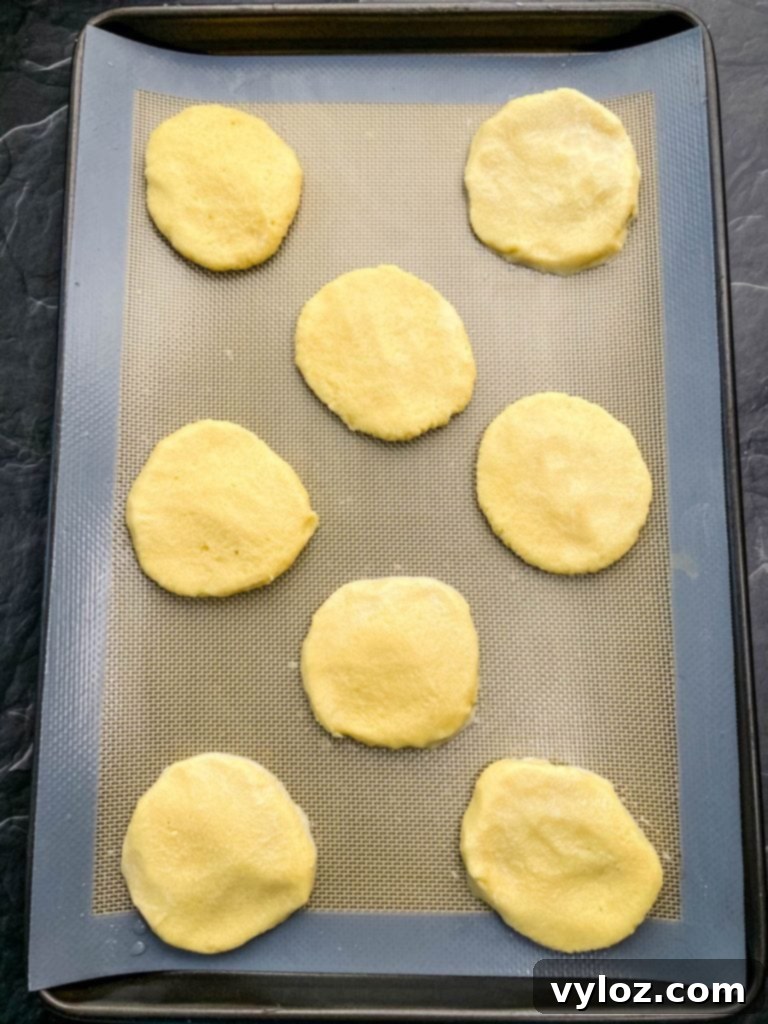 A stack of three keto low carb gluten free sugar cookies on a white plate, highlighting their appealing texture.