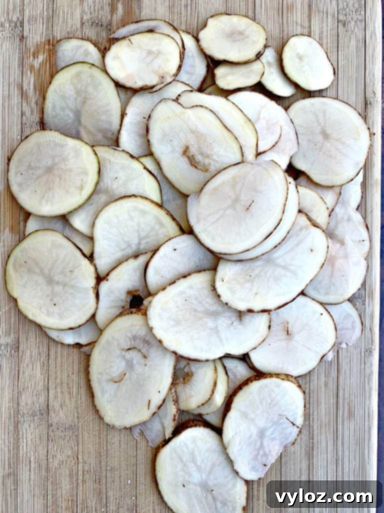 Crispy Air Fryer Homemade Potato Chips 5 Thinly sliced potatoes artfully arranged on a wooden cutting board.