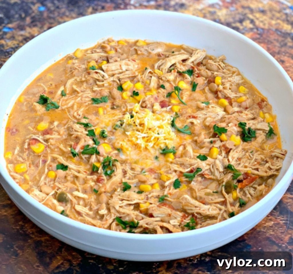 A bowl of creamy white chicken chili, garnished with fresh cilantro and a dollop of sour cream, ready to be enjoyed.
