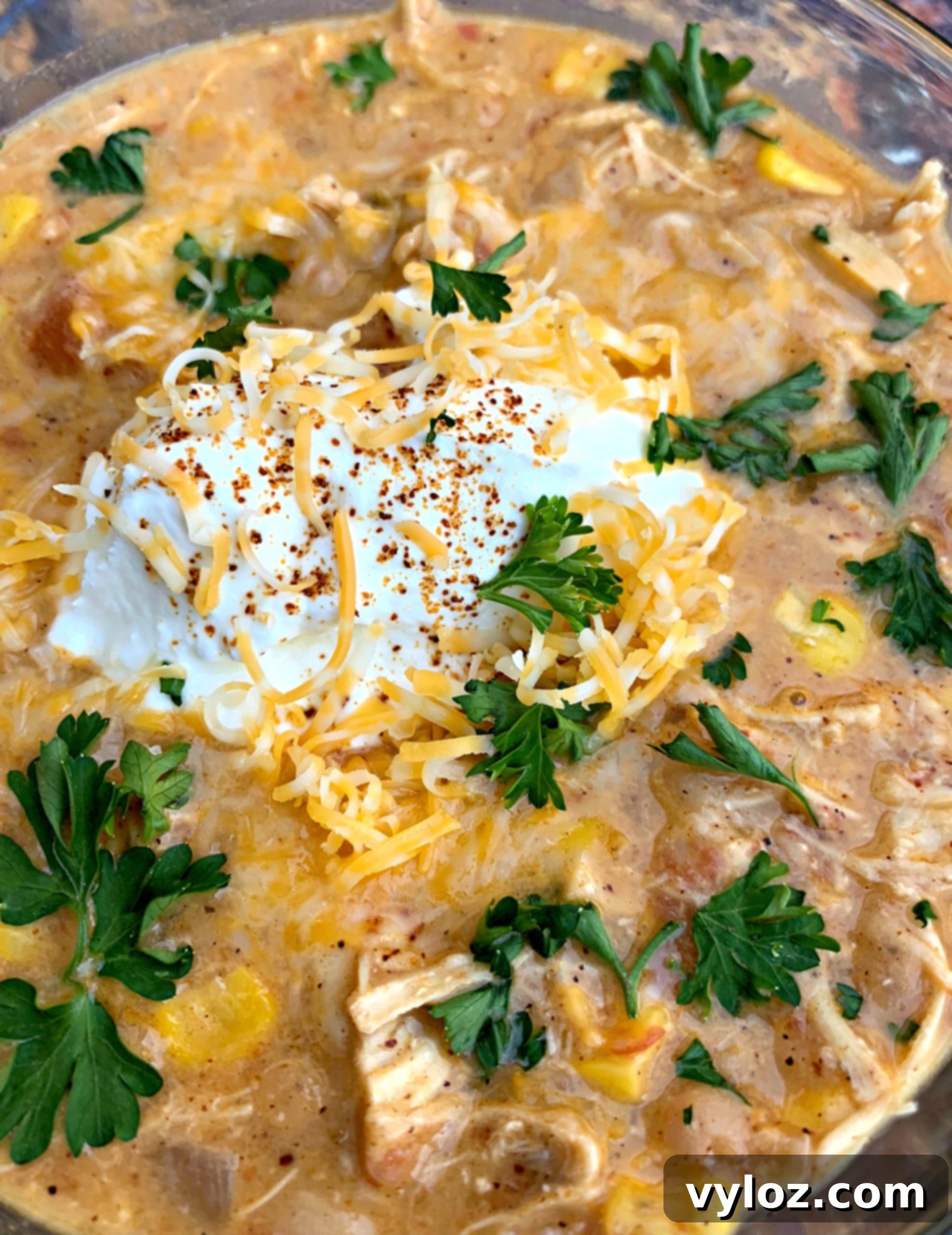A close-up shot of creamy white chicken chili, showcasing its rich texture and colorful toppings.