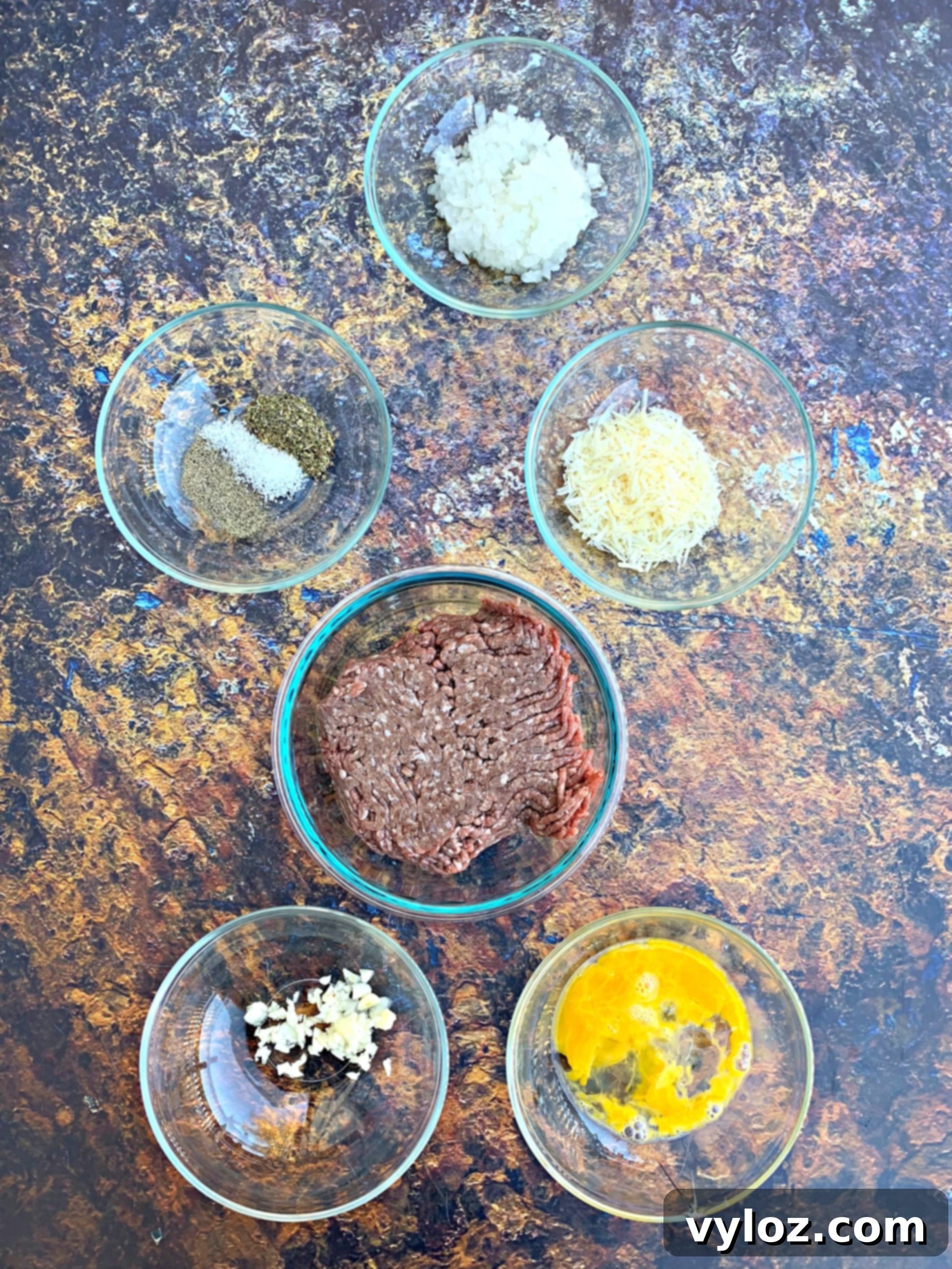 A vibrant selection of fresh ingredients, including a whole spaghetti squash, high-quality ground beef, chopped onions, minced garlic, and various seasonings, all meticulously laid out for preparing a keto low-carb spaghetti squash marinara dish.
