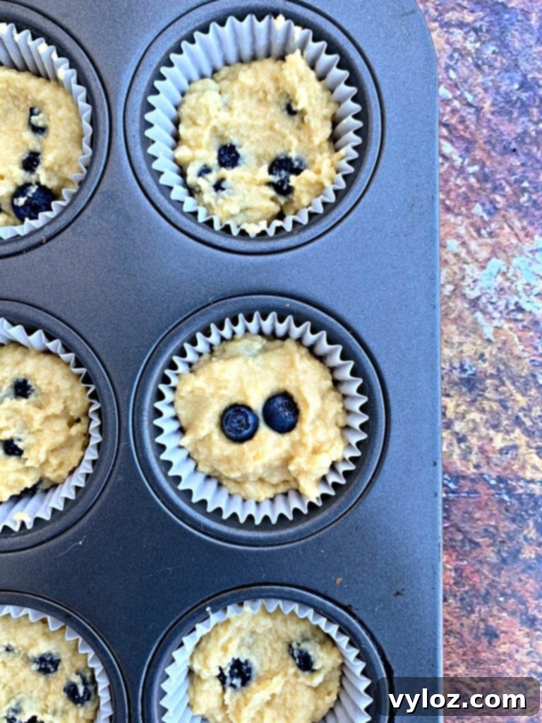 uncooked keto blueberry muffins in a muffin tin