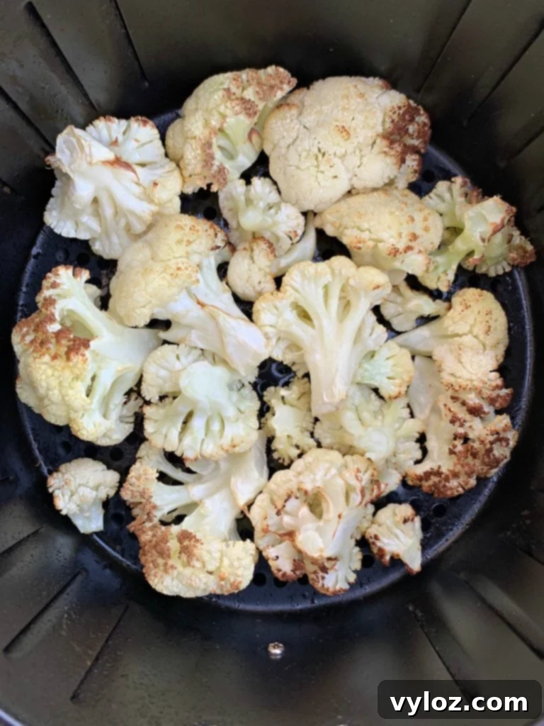 Crispy Air Fryer Buffalo Cauliflower 6 Partially cooked cauliflower in the air fryer, lightly browned and ready for sauce