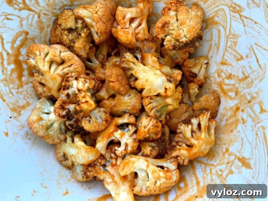 Crispy Air Fryer Buffalo Cauliflower 7 Chopped cauliflower florets in a bowl, tossed with vibrant buffalo sauce
