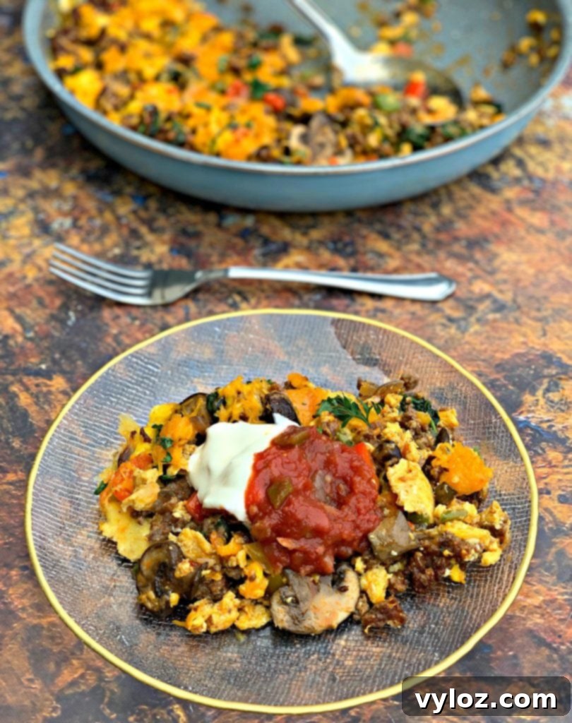 Keto Chorizo Egg and Cheese Breakfast Prep 13 keto low carb sausage breakfast scramble on a plate with salsa and sour cream