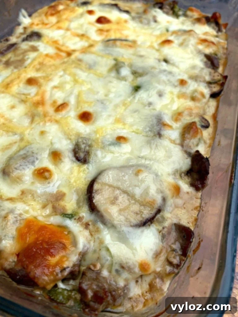 Overhead shot of Keto Low-Carb Philly Cheesesteak Casserole in a glass pan, perfectly baked.