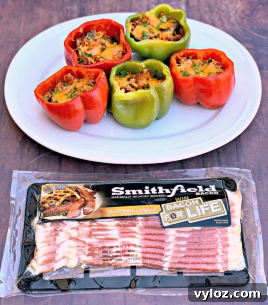 Delicious keto low-carb bacon, mushroom, and cheese stuffed peppers on a white plate, ready to serve.