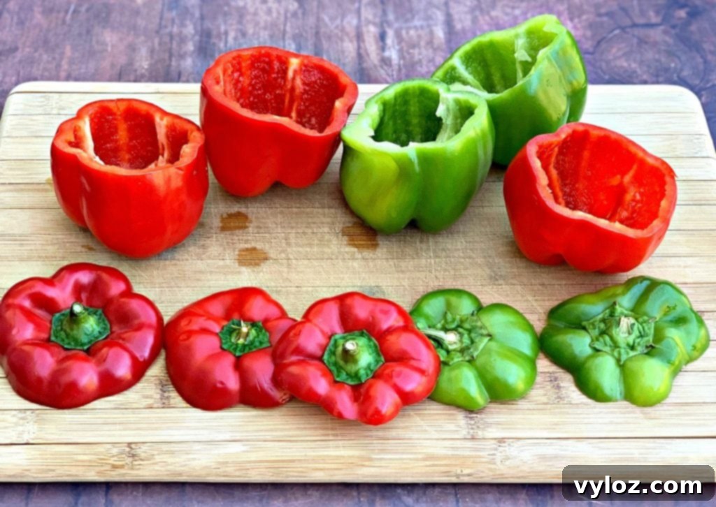 Vibrant red and green bell peppers resting on a wooden cutting board, ready for preparation.