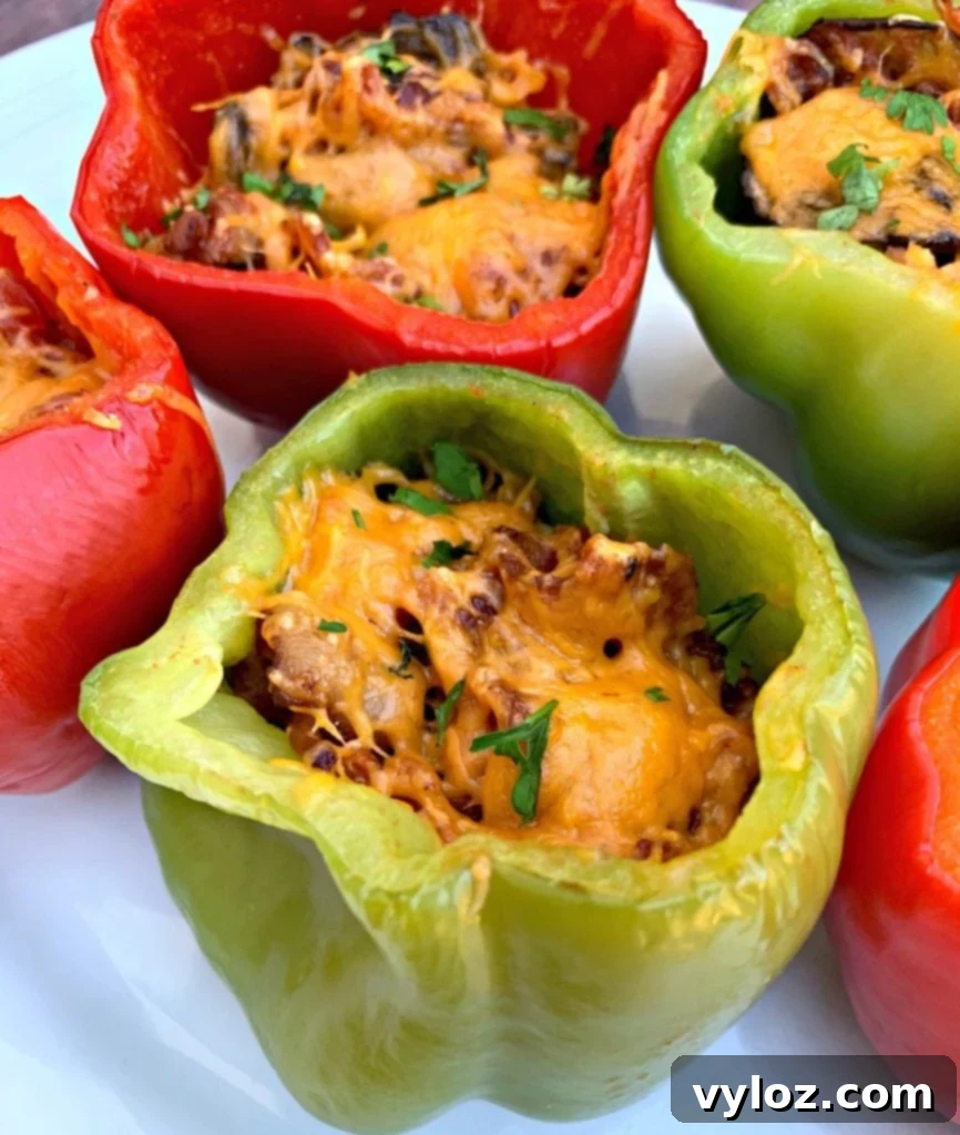 Another close-up of a keto low-carb bacon, mushroom, and cheese stuffed pepper on a white plate, highlighting its appetizing texture.