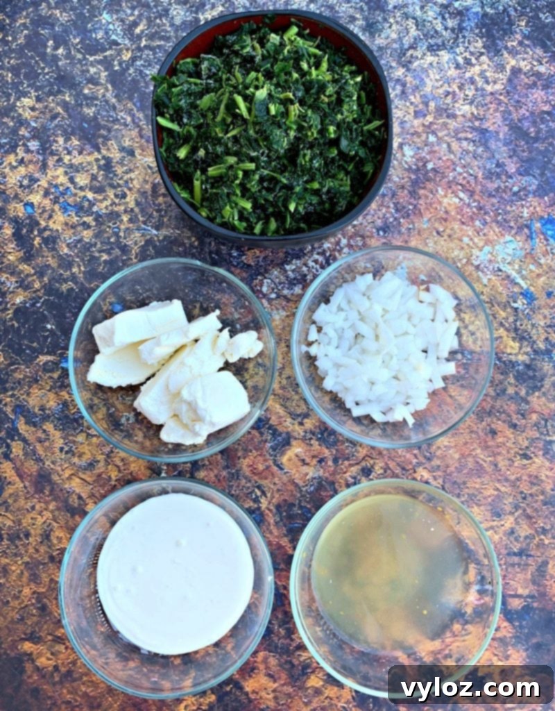 All the fresh ingredients laid out for keto low carb creamed spinach, including spinach, cream cheese, and garlic.