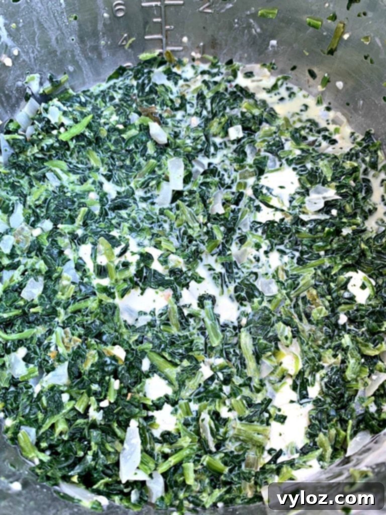 All ingredients for creamed spinach, including frozen spinach, cream cheese, and broth, mixed in an Instant Pot before cooking.