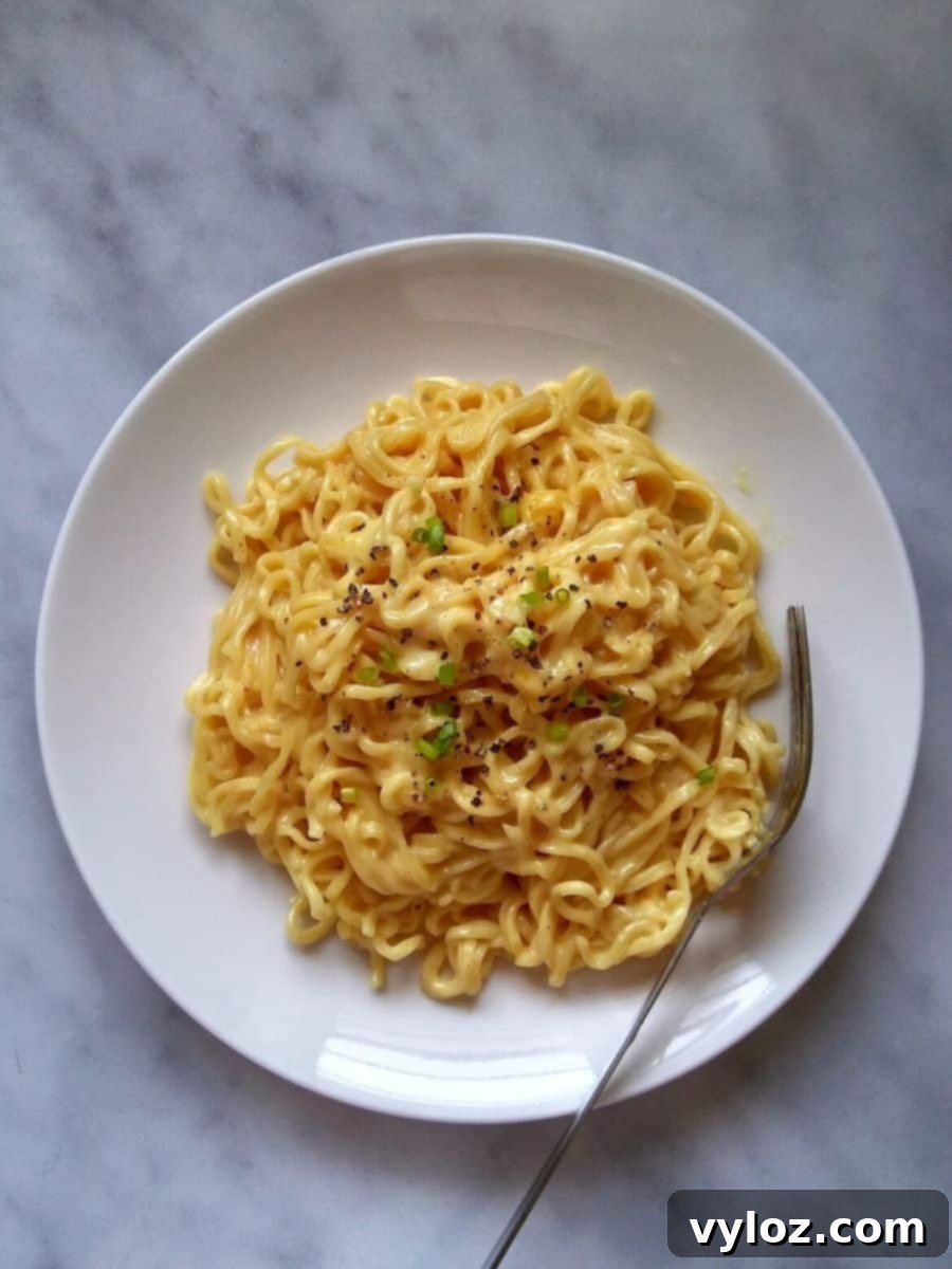 Instant ramen with melted cheese on a white plate, ready to eat