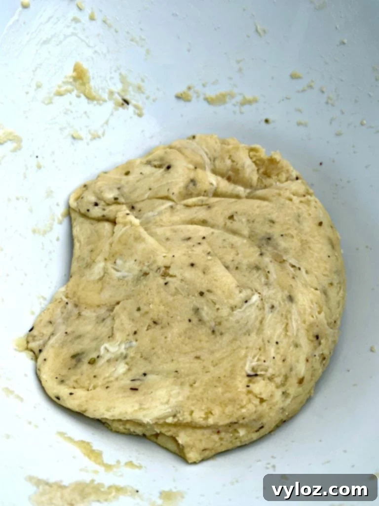 Keto pepperoni pizza dough in a mixing bowl, showing its soft, uniform consistency after combining ingredients.