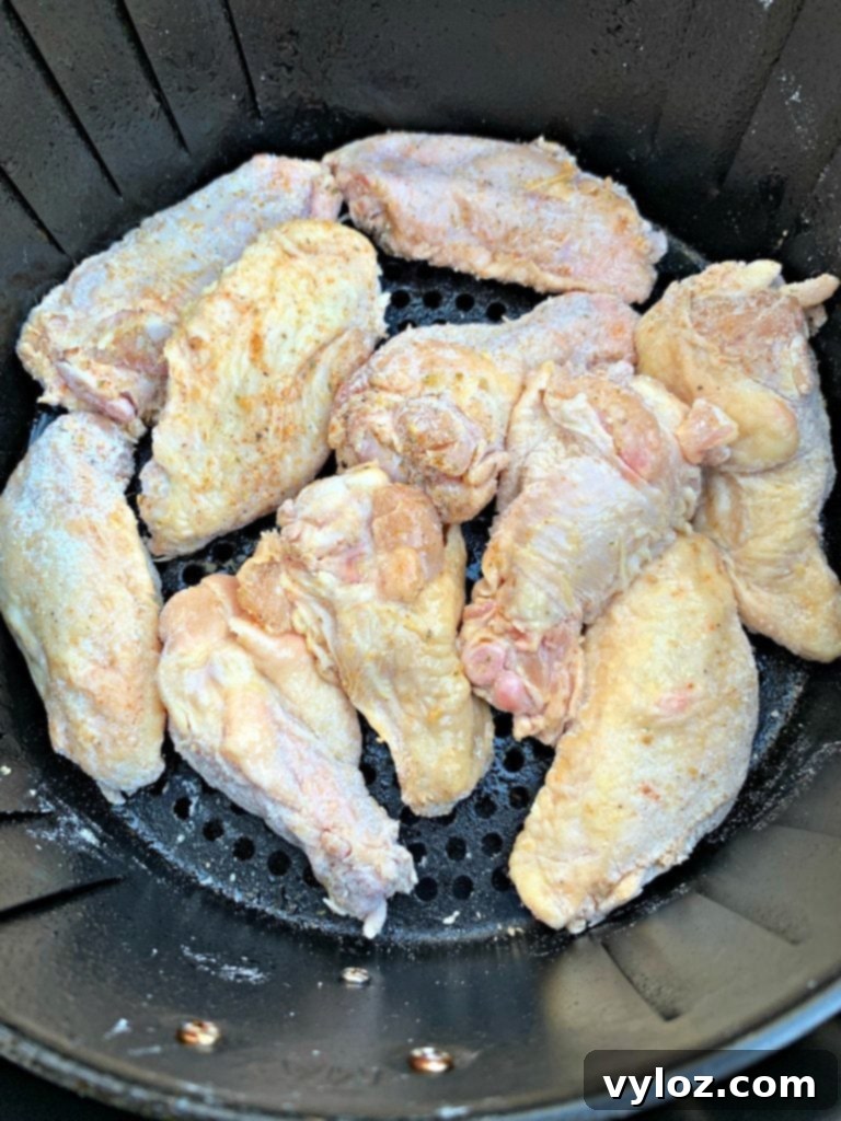 No-Fuss Sticky Honey BBQ Wings 4 Raw chicken wing placed in an air fryer basket, ready for cooking.