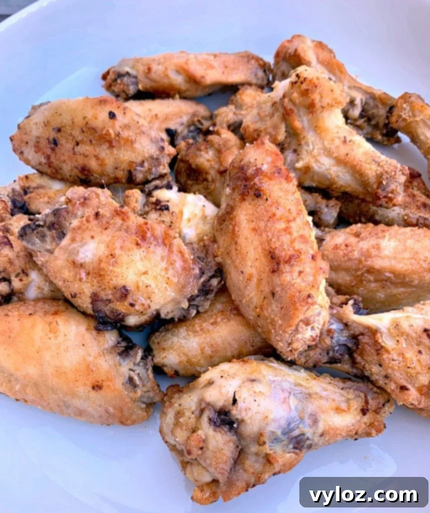 No-Fuss Sticky Honey BBQ Wings 6 A close-up of crispy fried chicken wings in a white bowl, showcasing their texture.