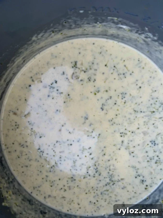 Creamy keto low carb instant pot broccoli cheddar soup simmering to perfection in an Instant Pot before serving.