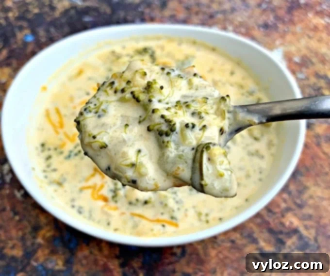 Another close-up of a spoonful of keto low carb instant pot broccoli cheddar soup, rich and appetizing.