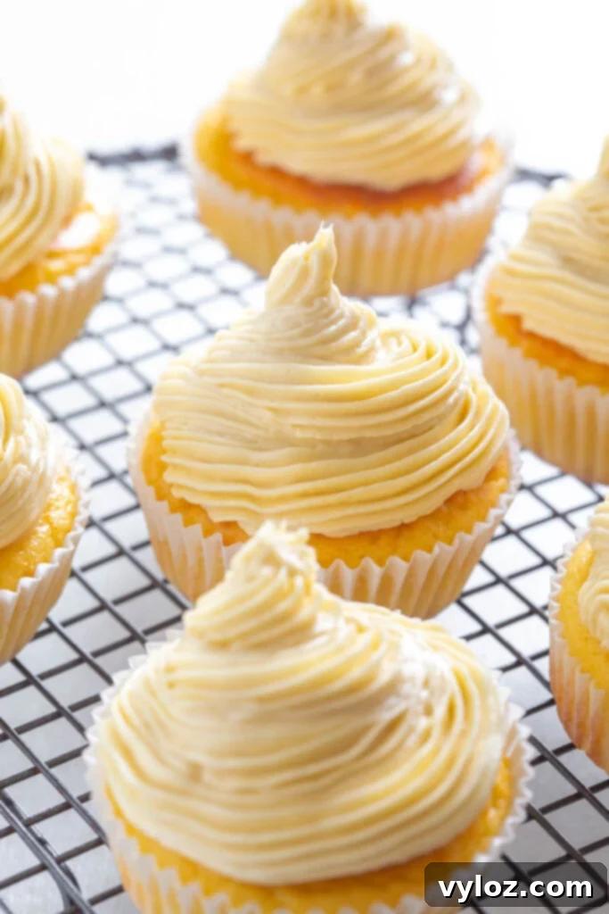 Delicious sugar-free vanilla cupcakes cooling on a wire rack, ready for luscious frosting.