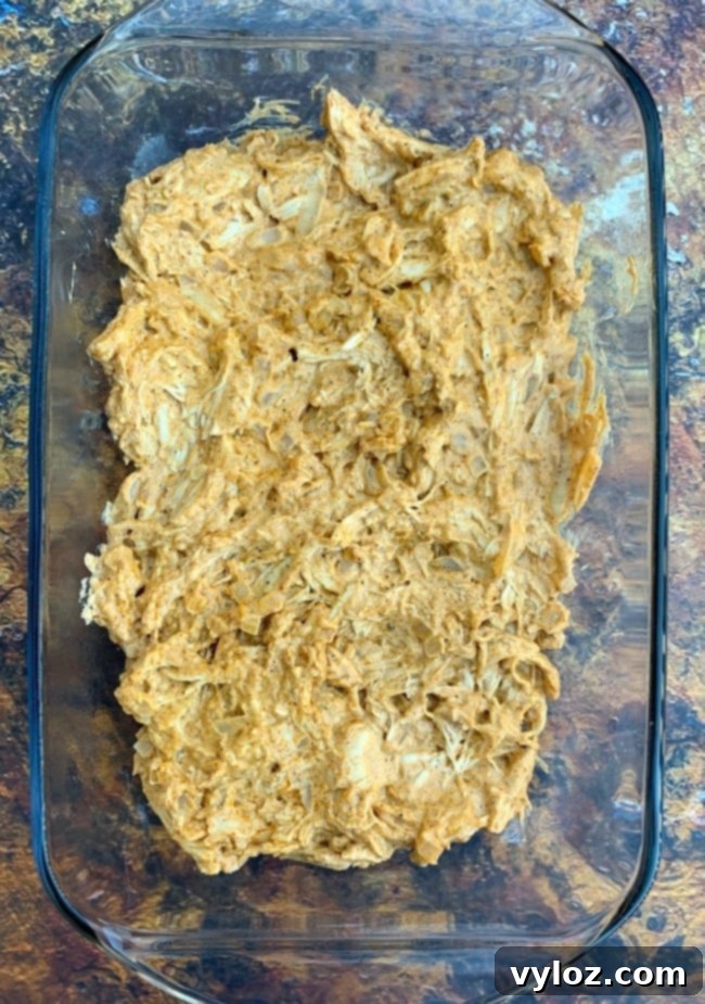 melted cheese and shredded chicken in a baking dish