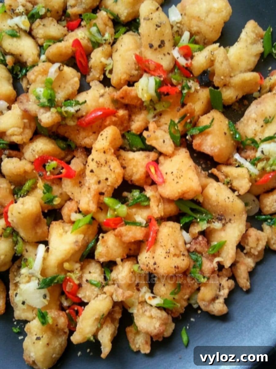 Chinese salt and pepper chicken served on a black plate