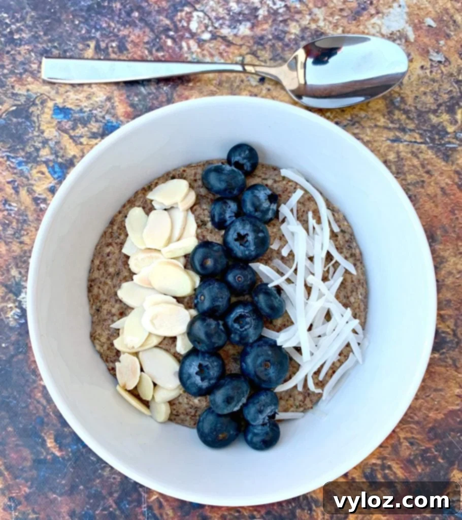 Keto hemp oatmeal with blueberries, almonds, and coconut in a white bowl