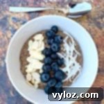 Keto hemp oatmeal with blueberries, almonds, and coconut in a white bowl