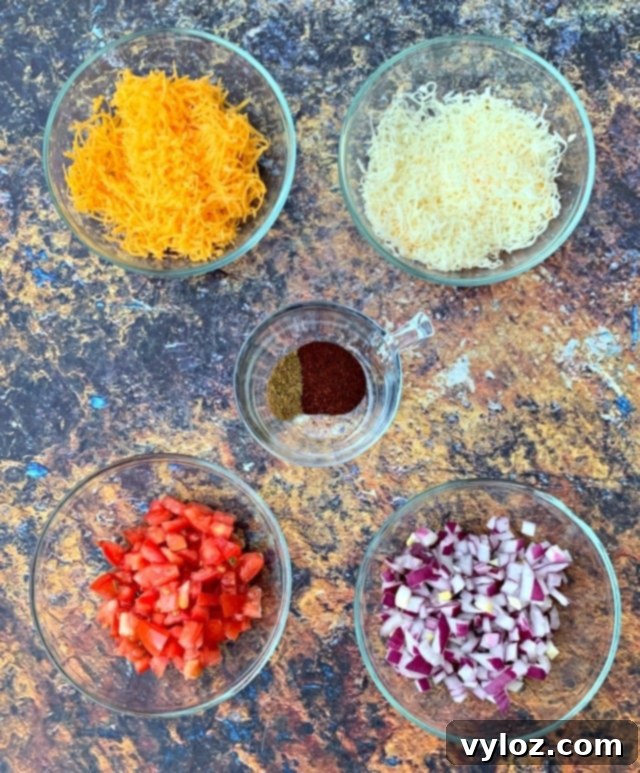 Assortment of fresh ingredients for air fryer chicken quesadillas, including shredded chicken, cheese, and fresh vegetables