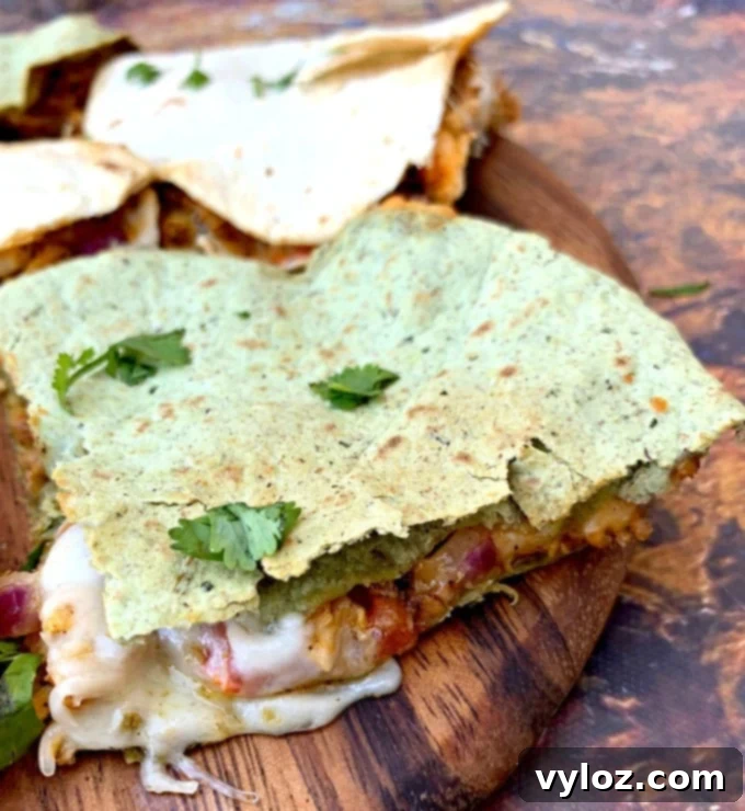 Freshly cooked air fryer chicken quesadillas, sliced into perfect wedges on a rustic brown serving board