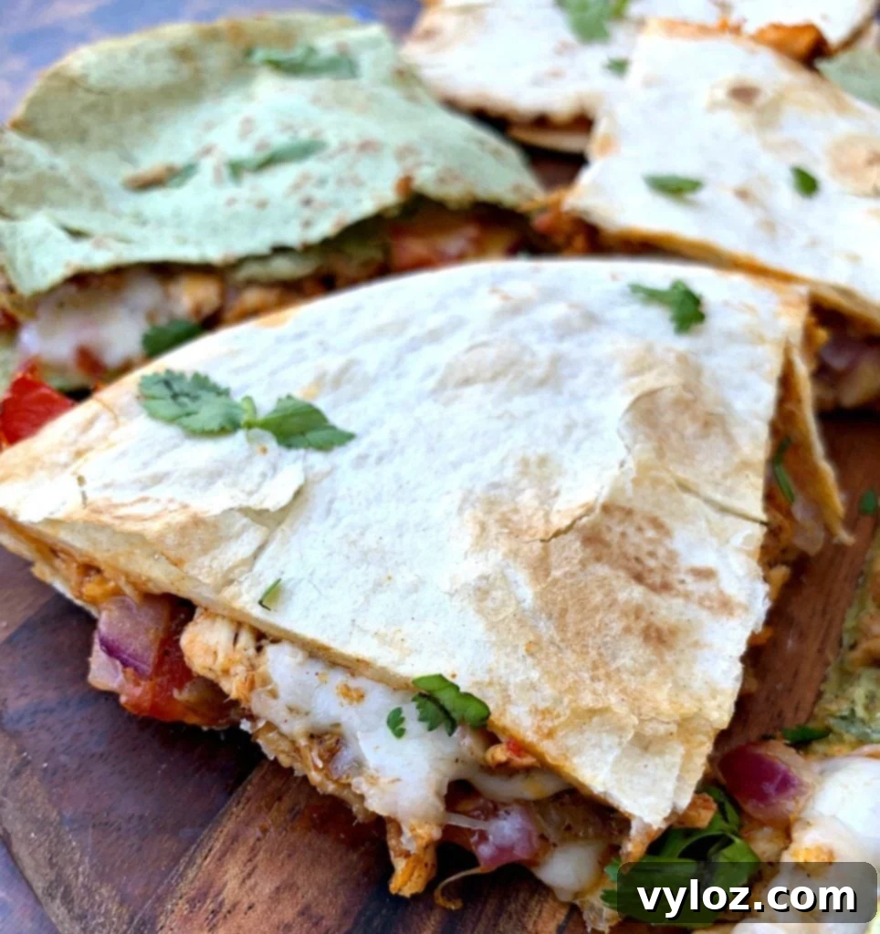Beautifully arranged air fryer chicken quesadillas on a brown cutting board, showcasing their golden-brown exterior