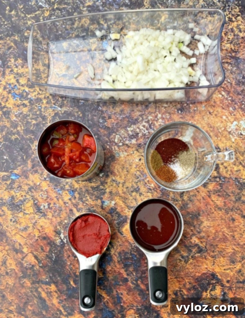 Assortment of fresh vegetables including onions, garlic, and various bell peppers, alongside a vibrant array of spices, ready for a keto beef chili recipe.
