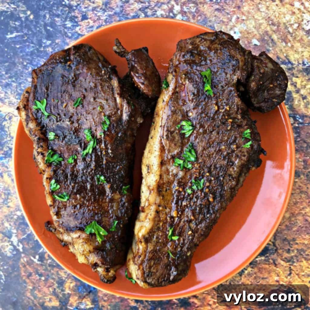 Air fryer steaks on an orange plate, a quick and easy meal with Butcher Box steaks.