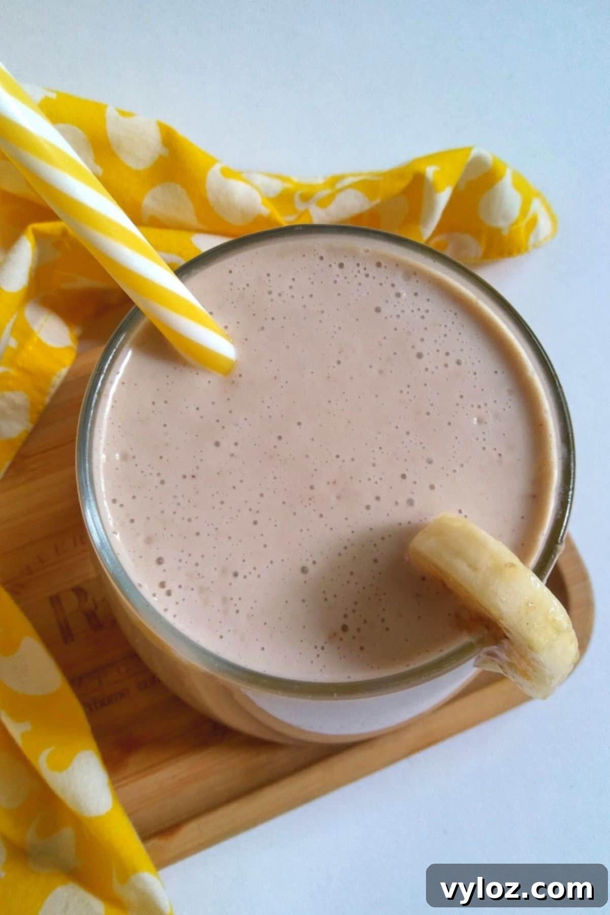 A tall glass of frothy, creamy banana milkshake, ready to be enjoyed.