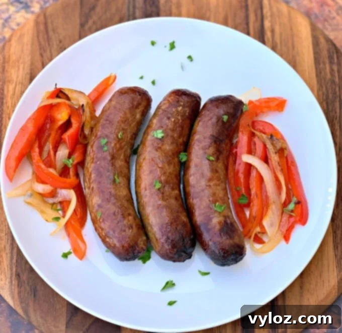cooked air fryer sausage on a plate with peppers