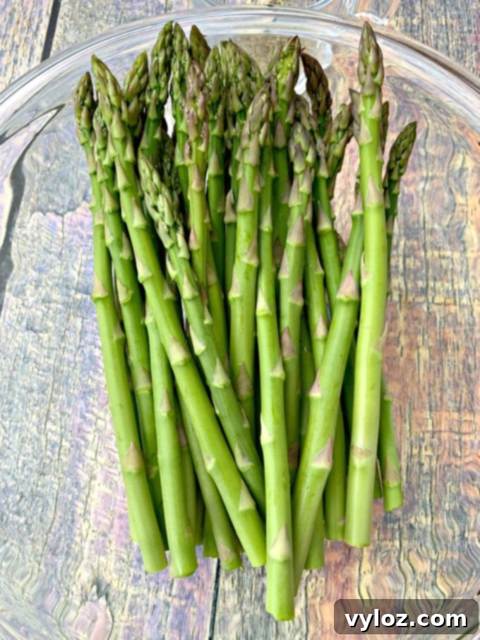 Washed and trimmed raw asparagus in a glass bowl