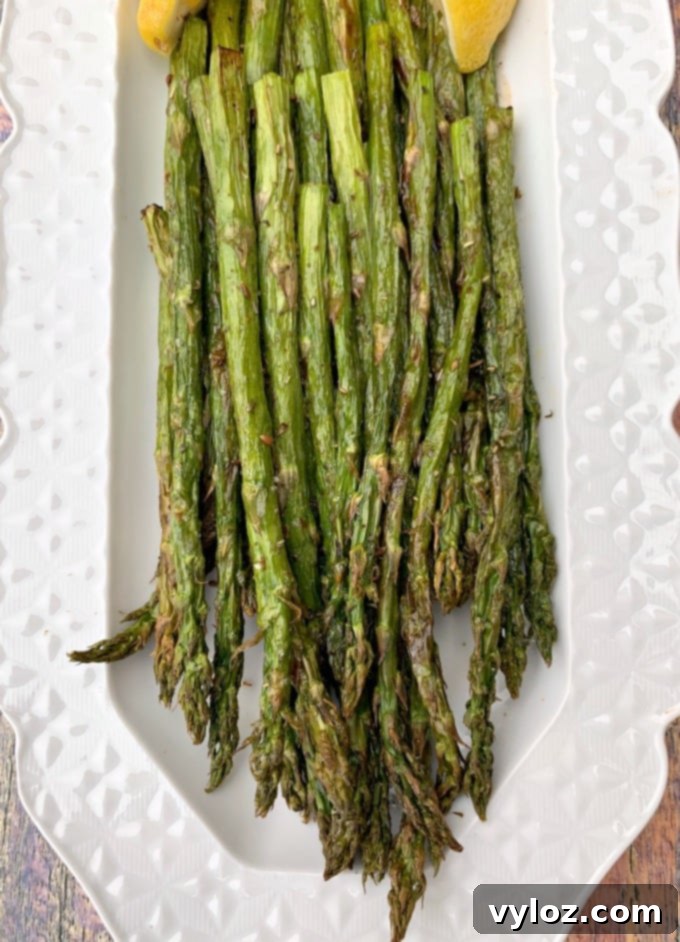 Air-fried roasted asparagus on a white plate, ready to be served