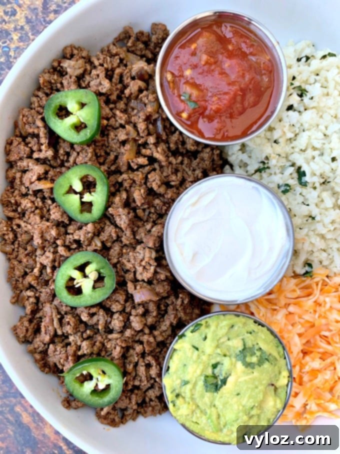 30 Minute Taco Bowl 6 keto low carb tacos in a white bowl with cilantro lime cauliflower rice, salsa, guacamole, and salsa