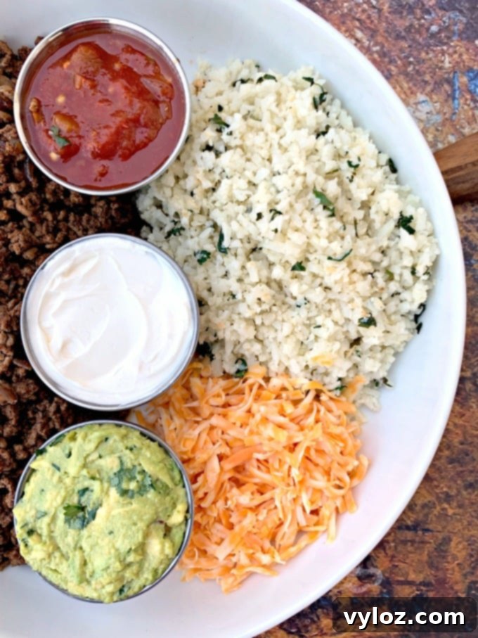 30 Minute Taco Bowl 7 keto low carb tacos in a white bowl with cilantro lime cauliflower rice, salsa, guacamole, and salsa