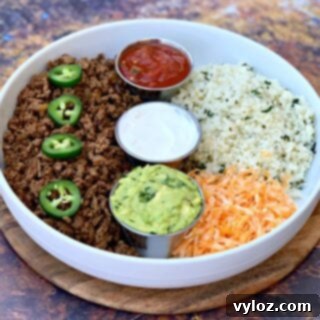 30 Minute Taco Bowl 10 keto low carb tacos in a white bowl with cilantro lime cauliflower rice, salsa, guacamole, and salsa