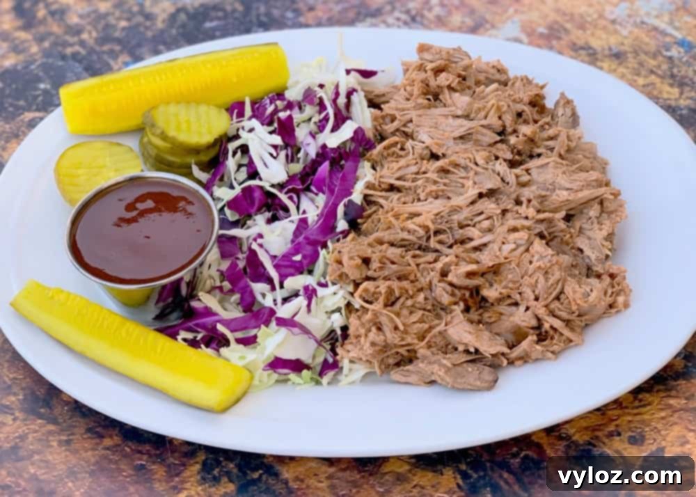 instant pot pulled pork on a plate with cabbage and pickles