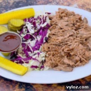 instant pot pulled pork on a plate with cabbage and pickles