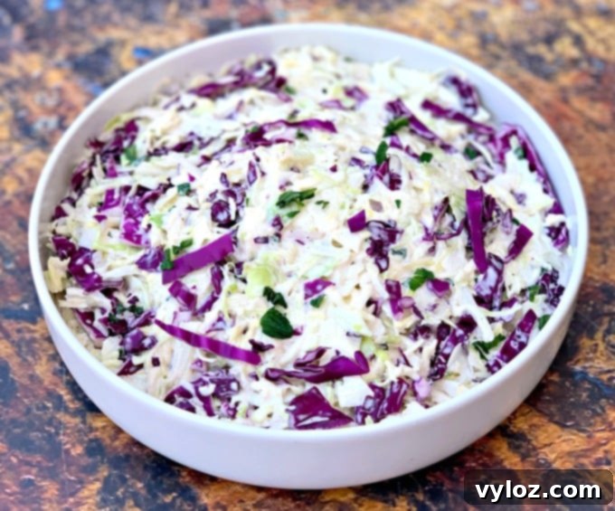 keto low carb coleslaw in a white bowl alongside pulled pork and pickles