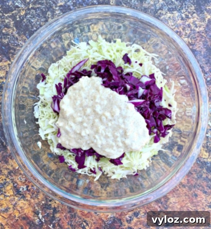 keto low carb coleslaw in a glass bowl with liquid mixture on top