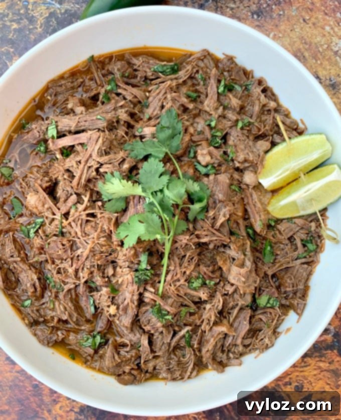 Instant Pot Chipotle Barbacoa Beef 9 Instant Pot keto low carb barbacoa beef with cilantro and limes in a white serving bowl
