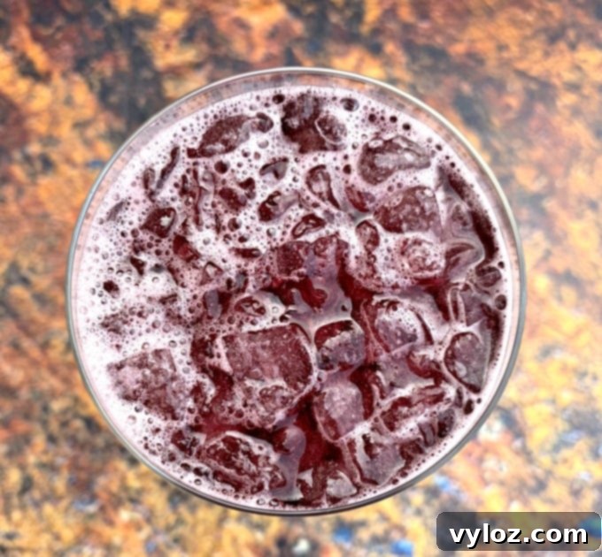 A close-up shot of keto low carb red wine sangria in a wine glass with ice, highlighting its rich color and refreshing condensation.