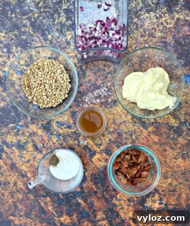 Ingredients for Keto Low Carb Broccoli Salad laid out: broccoli, mayo, red onion, sunflower seeds, bacon, sweetener, apple cider vinegar