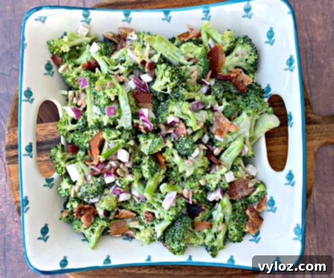 Close-up of creamy Keto Low-Carb Broccoli Salad with Bacon, red onions, and sunflower seeds in a blue bowl