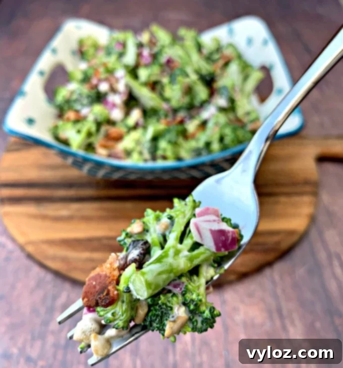 A fork holding a portion of Keto Low-Carb Broccoli Salad with Bacon, showcasing its creamy texture and fresh ingredients